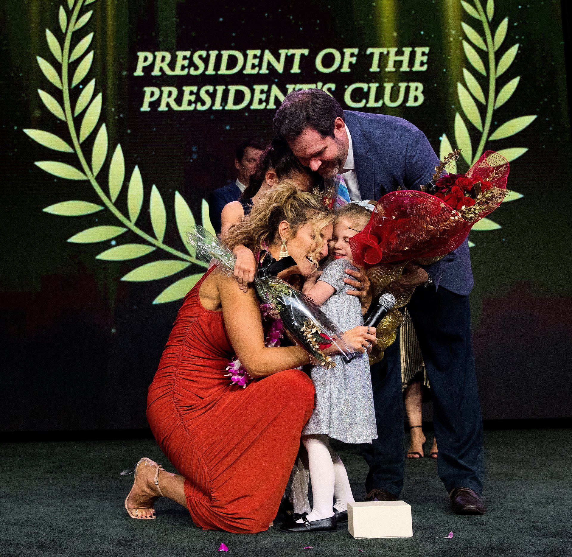 employees get emotional as they accept awards with family at corporate event