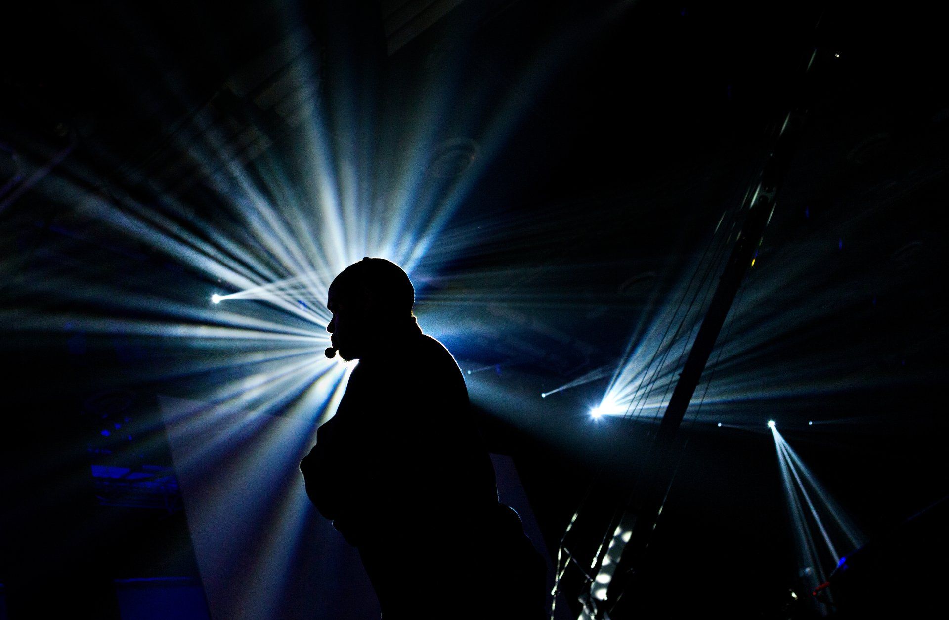 Speaker with lighting on stage giving talk to company