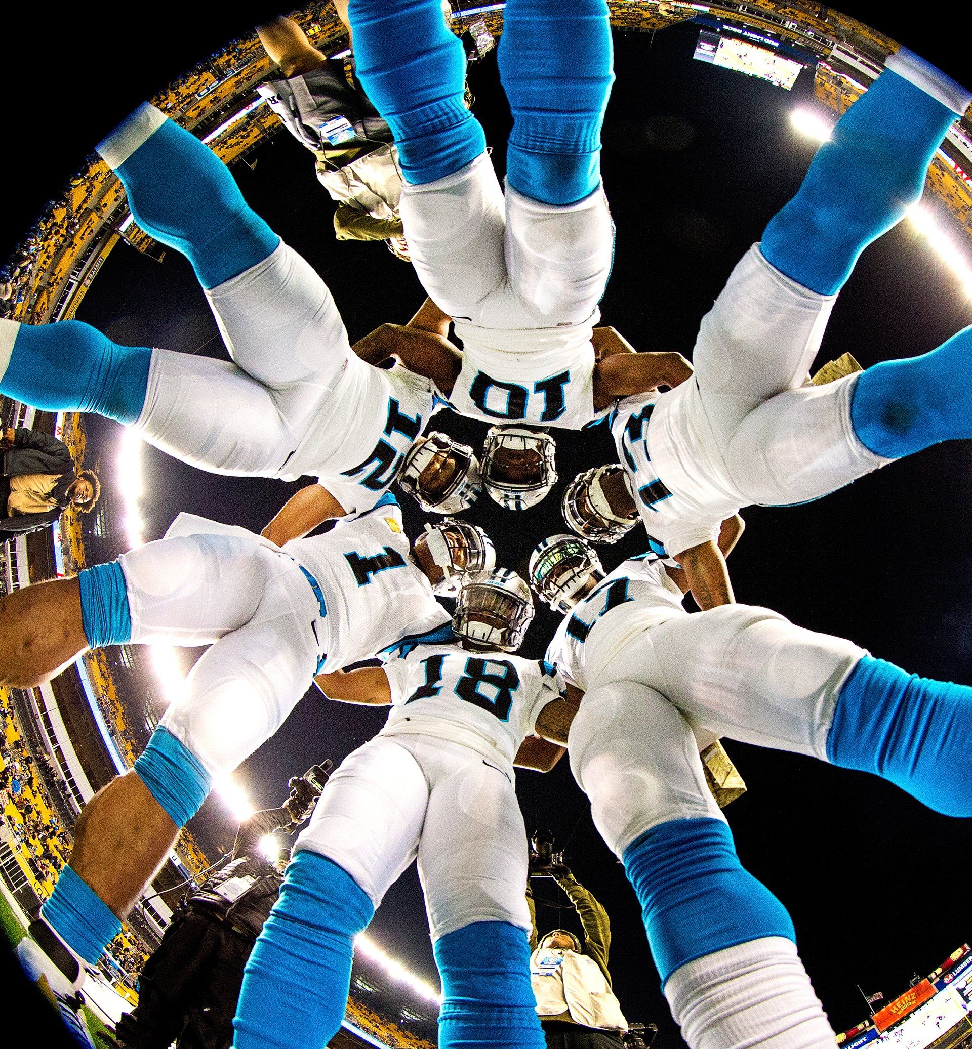 Creative angle shows the inside of a Carolina Panthers football team huddle