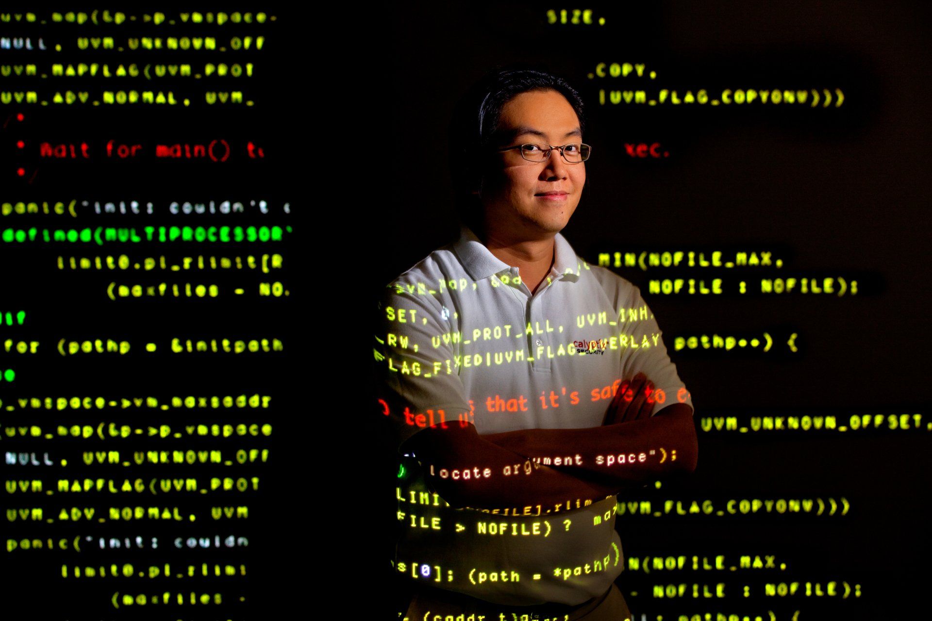 Photographic portrait of programmer with code projected on and around him
