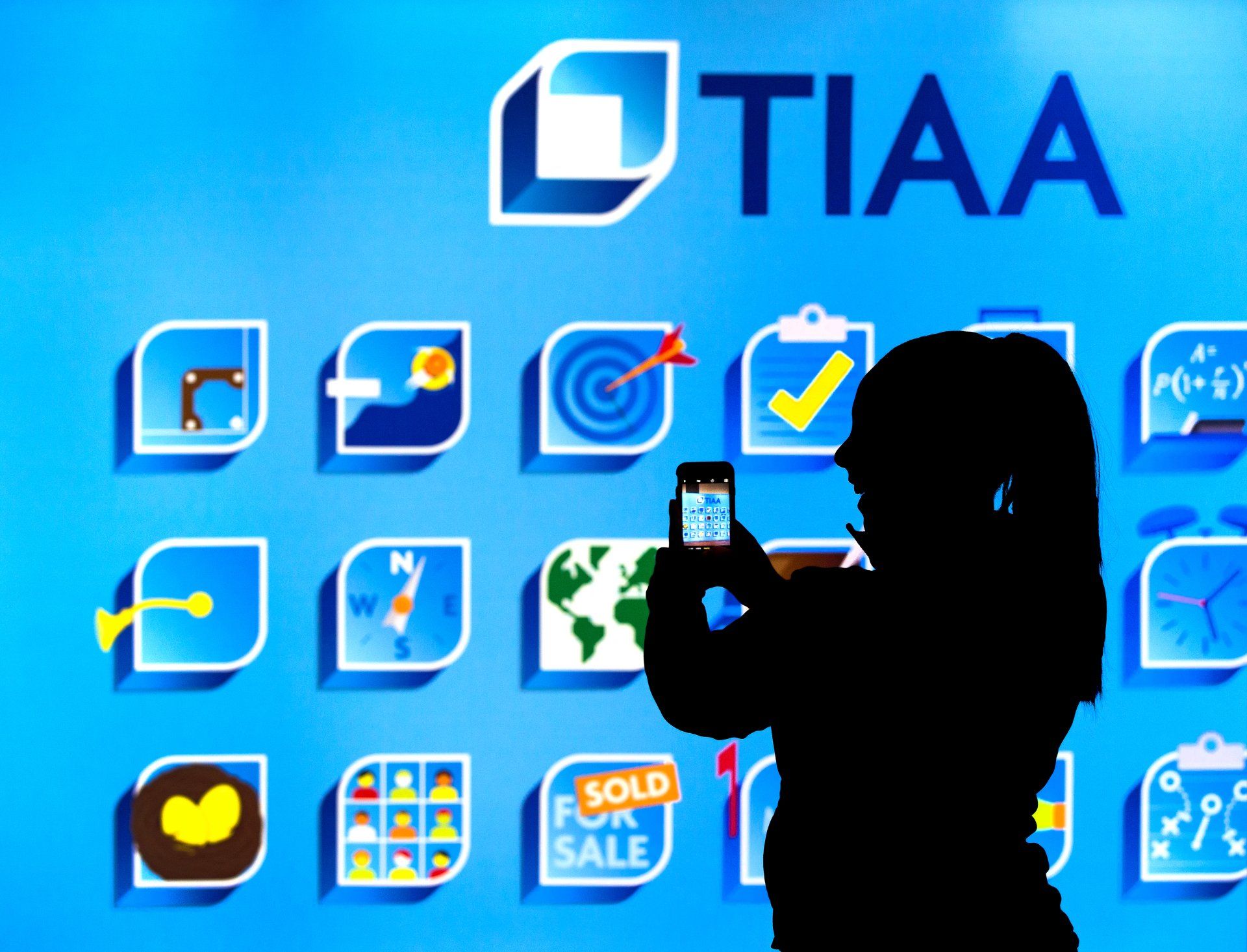 Employee takes a photo of backdrop at executive gathering