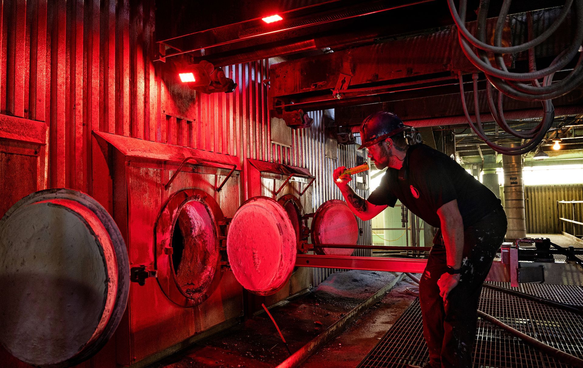 Steel fabrication specialist performing quality control inspection on manufacturing floor, ensuring production excellence.