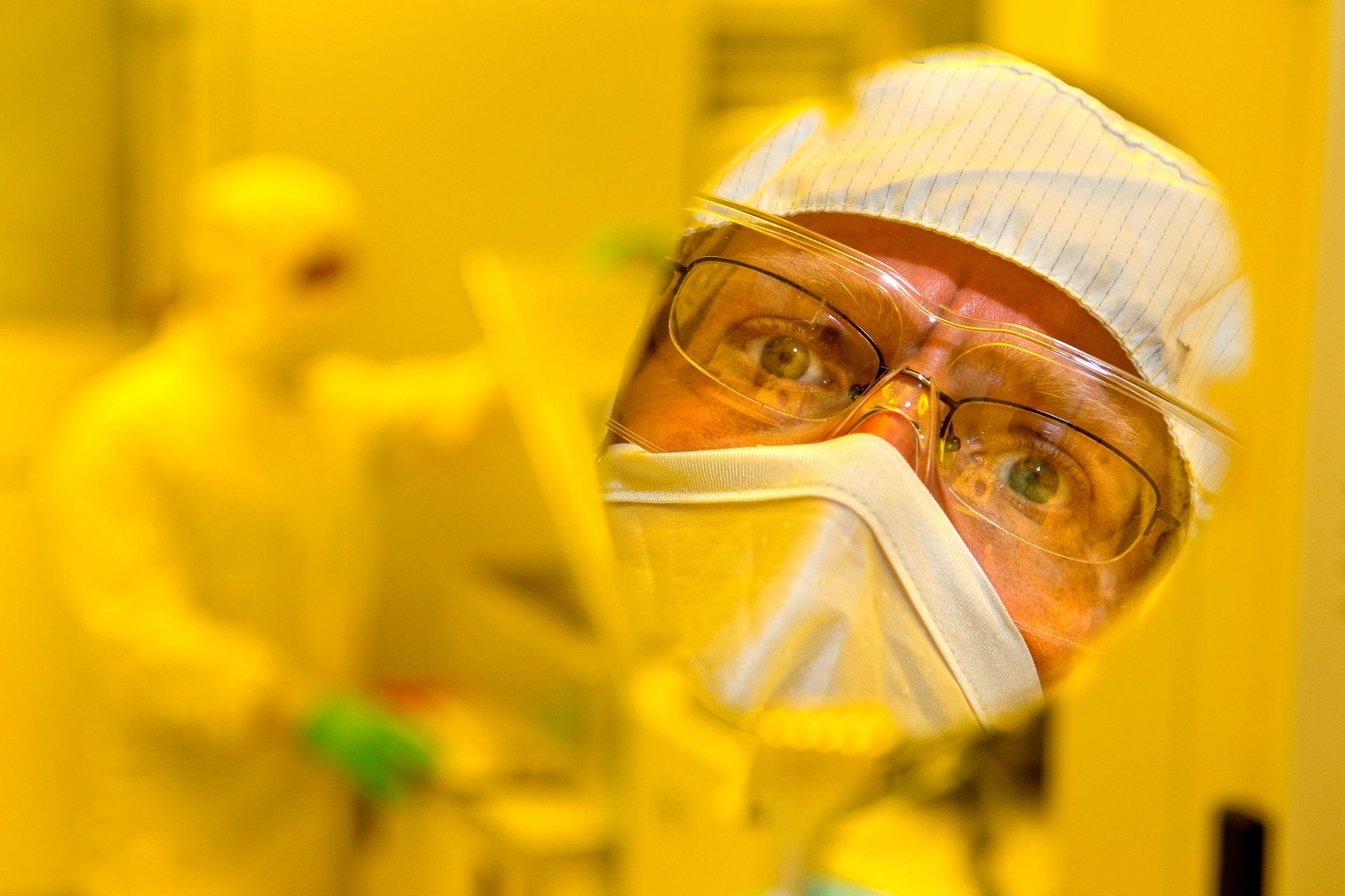 scientist in protective gear and safety glasses at an industrial complex