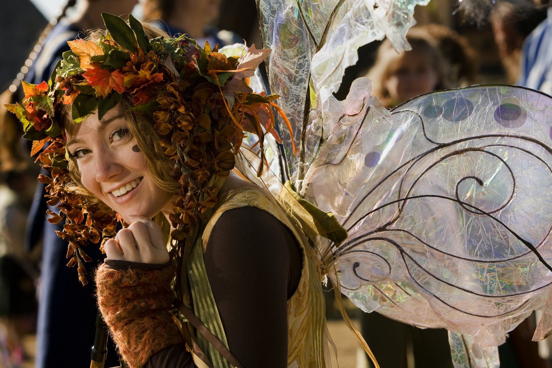 A woman in costume with butterfly wings at a festival