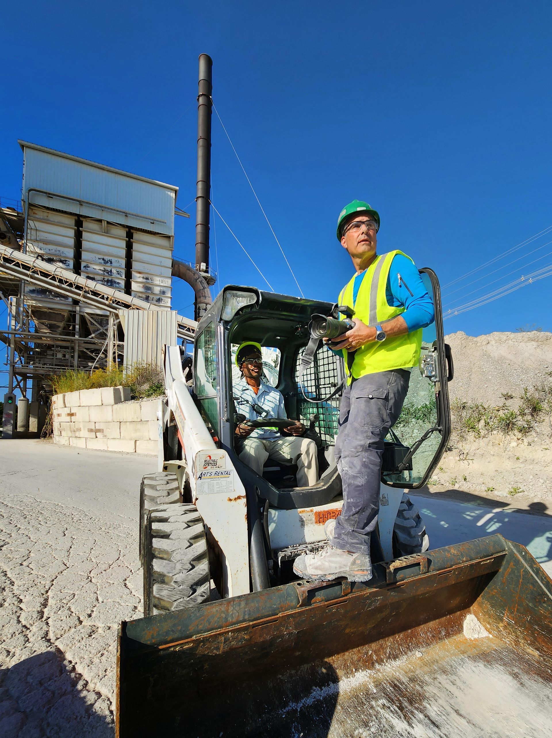 While others shoot from a distance, we position ourselves in the heart of the action to capture genuine industrial processes and skilled labor. In this image, photographer Patrick Schneider shows the employee driving a bulldozer how he plans to frame the image to showcase the worker in action.