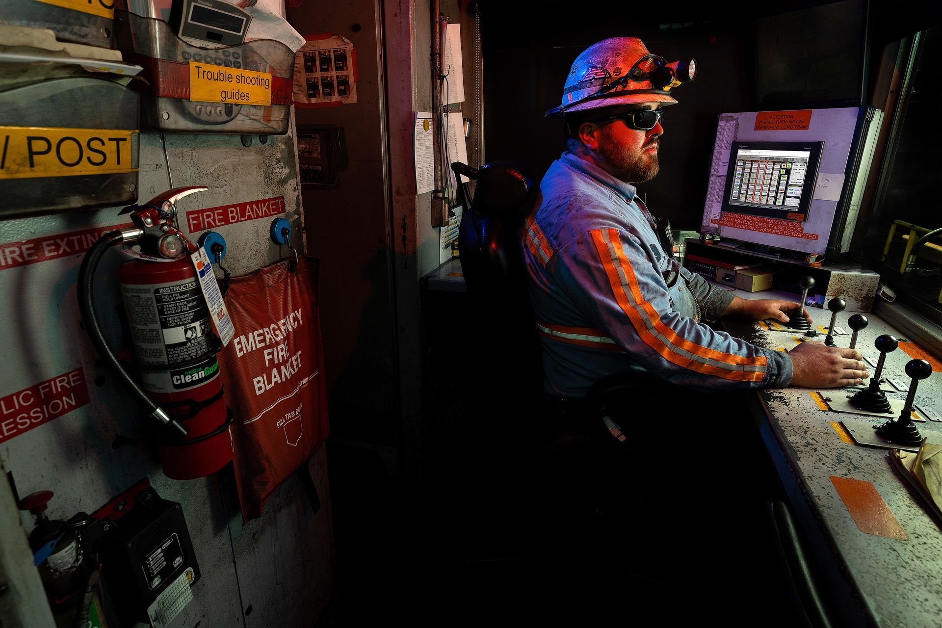 An operator mans the controls at an industrial plant. 
