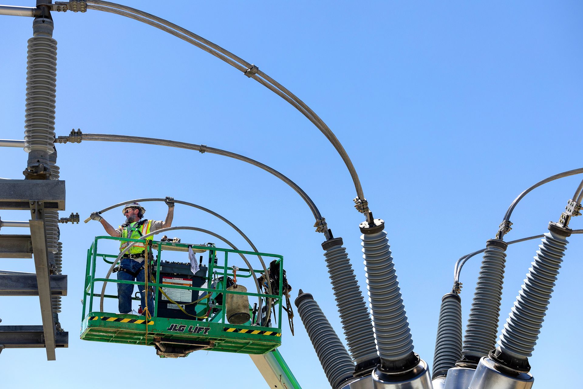 A utility worker installs electric lines in a new electric substation.