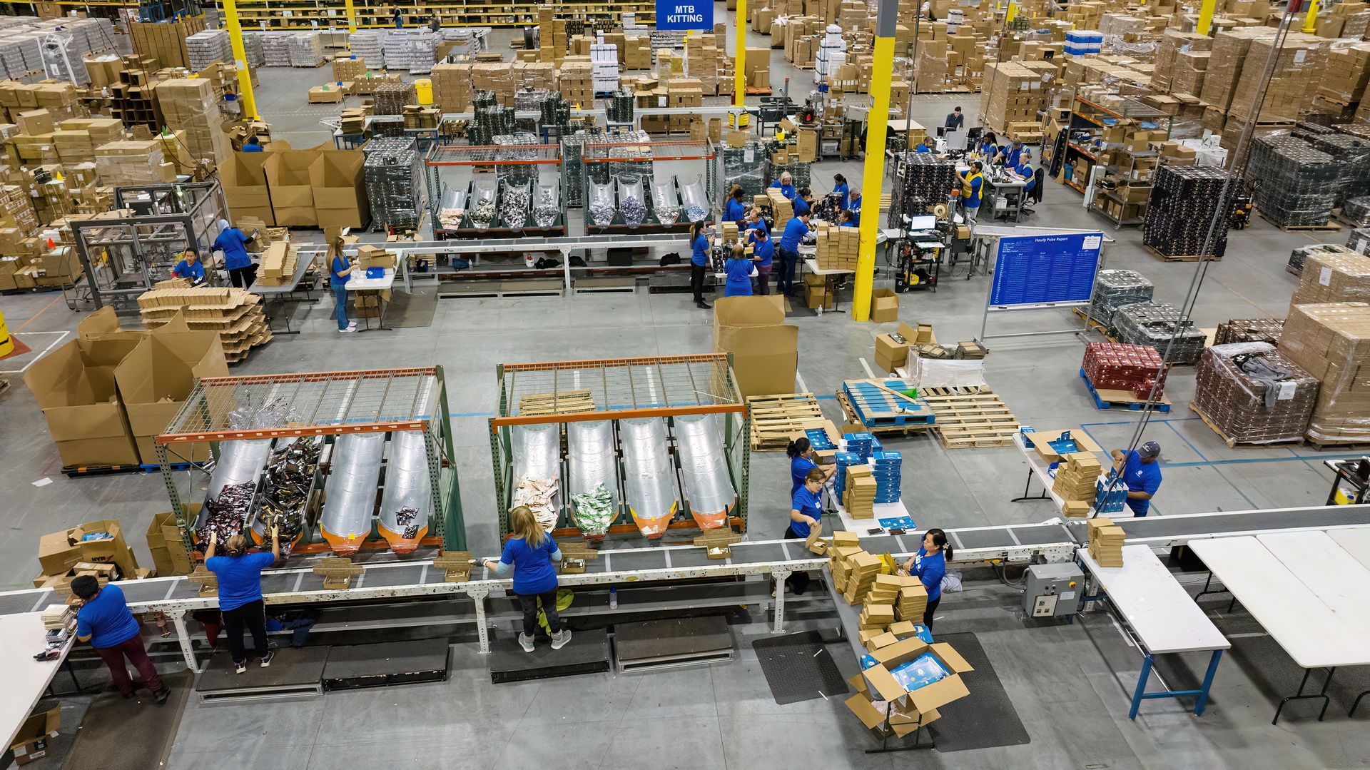 Workers in a manufacturing plant assemble products in the facility. Photo taken using drone technology. 