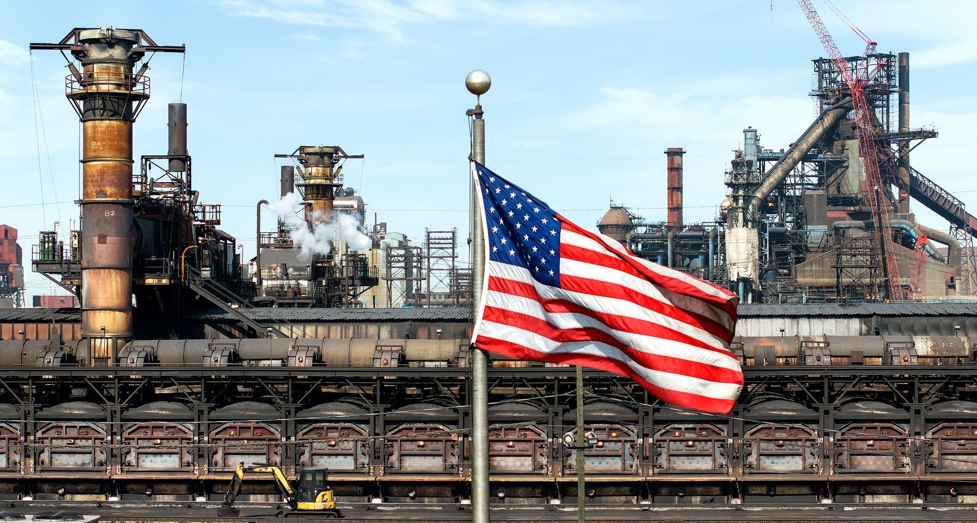An American flag flys next to a manufacturing industrial facility. Photographer used drone technnology to show the size and scale of the facility. 
