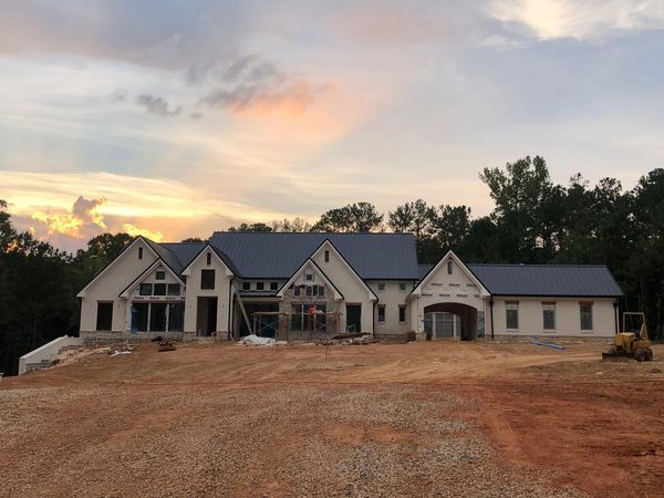 A man wearing a hard hat and goggles is standing in a room.