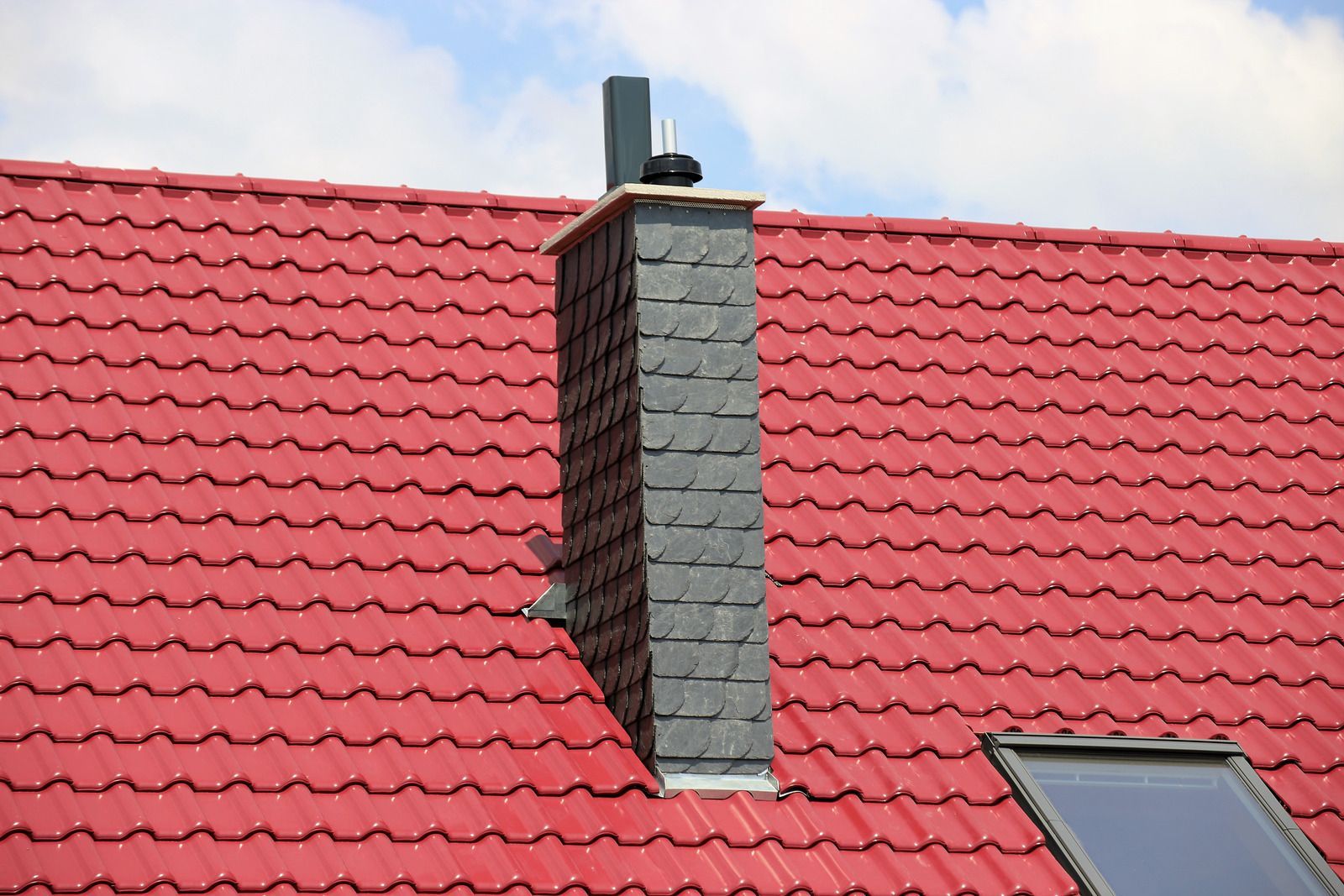 A yellow excavator is sitting on top of a pile of gravel.