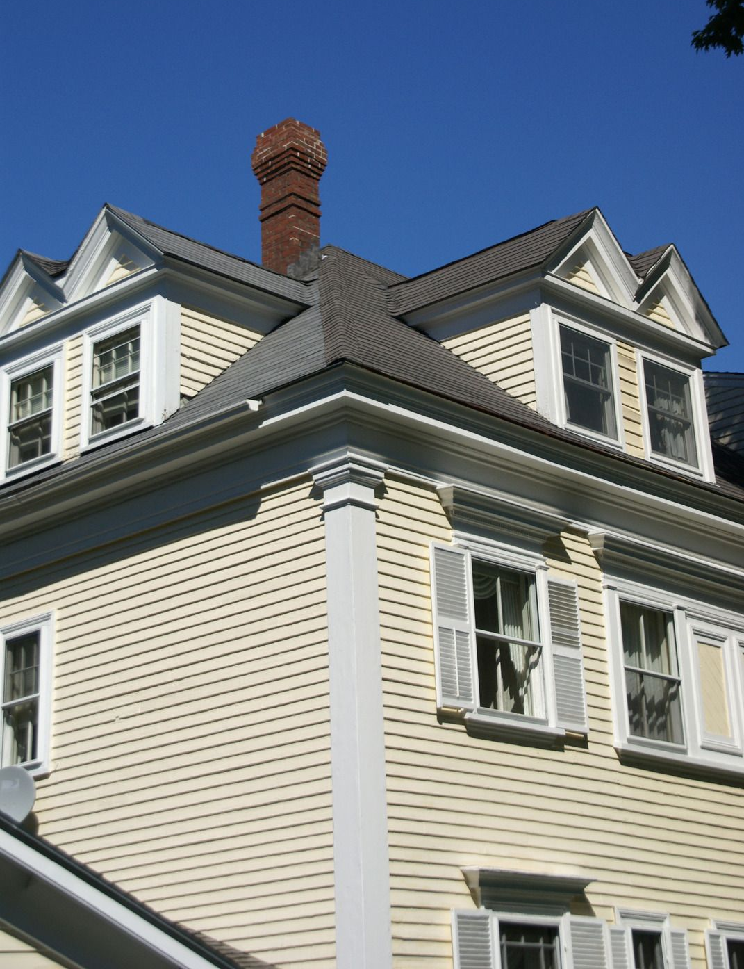 A yellow excavator is sitting on top of a pile of gravel.