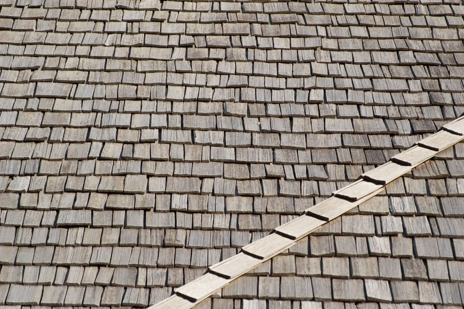 A man wearing a hard hat and goggles is standing in a room.