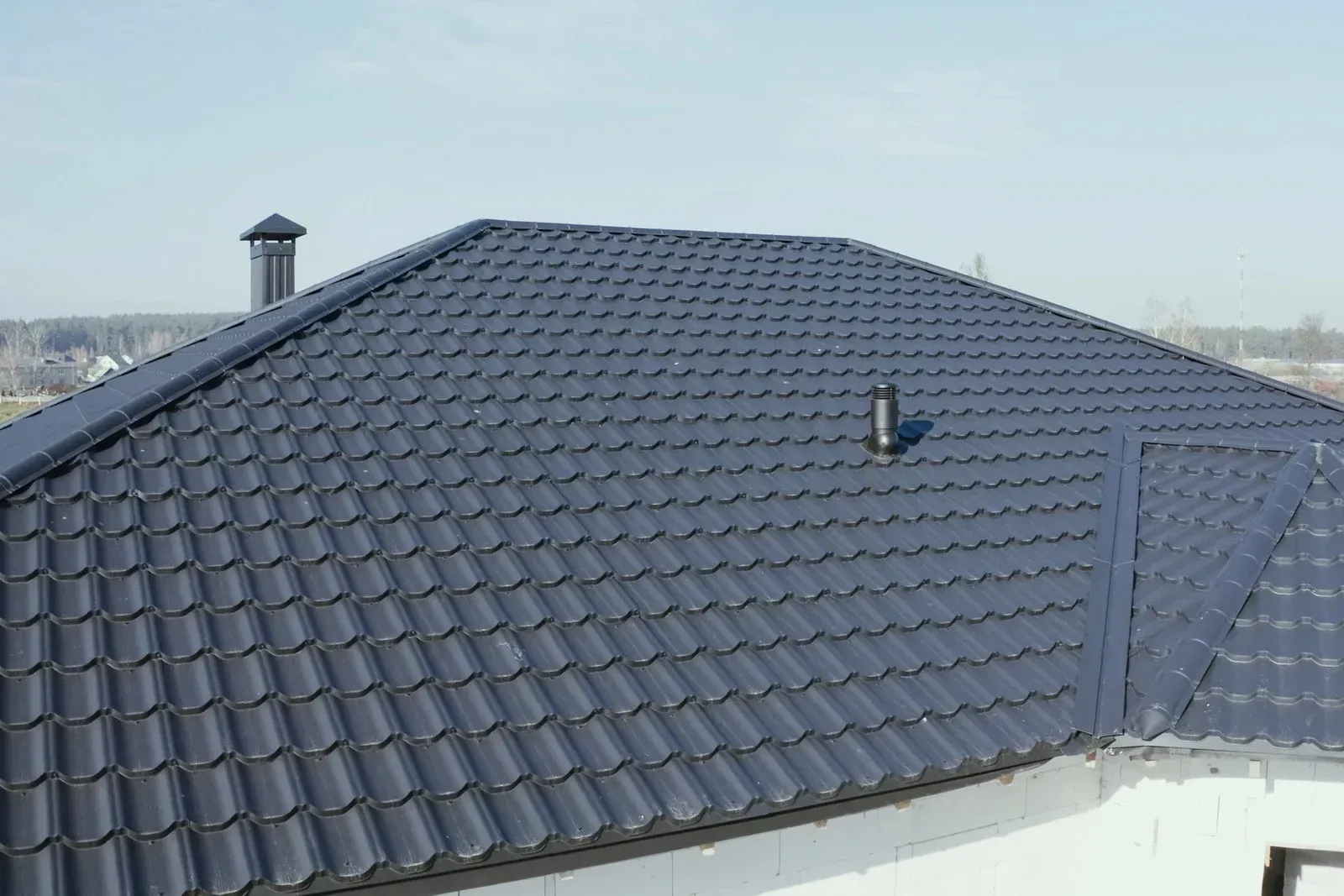A yellow excavator is sitting on top of a pile of gravel.