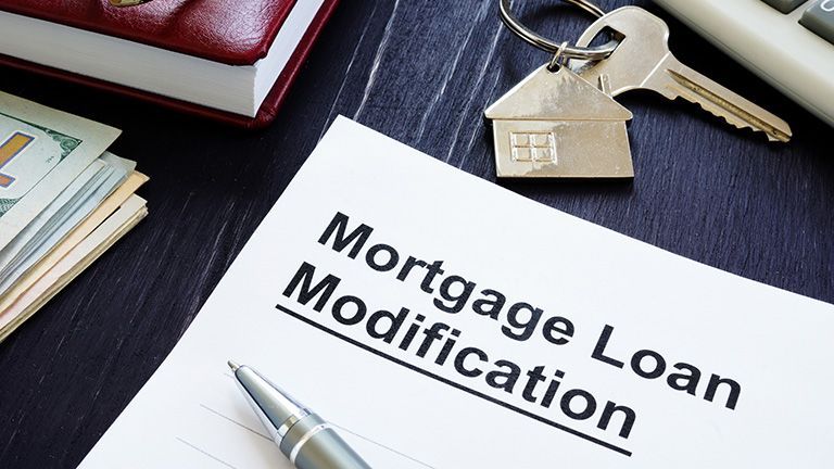 A pen is sitting on top of a mortgage loan modification form.