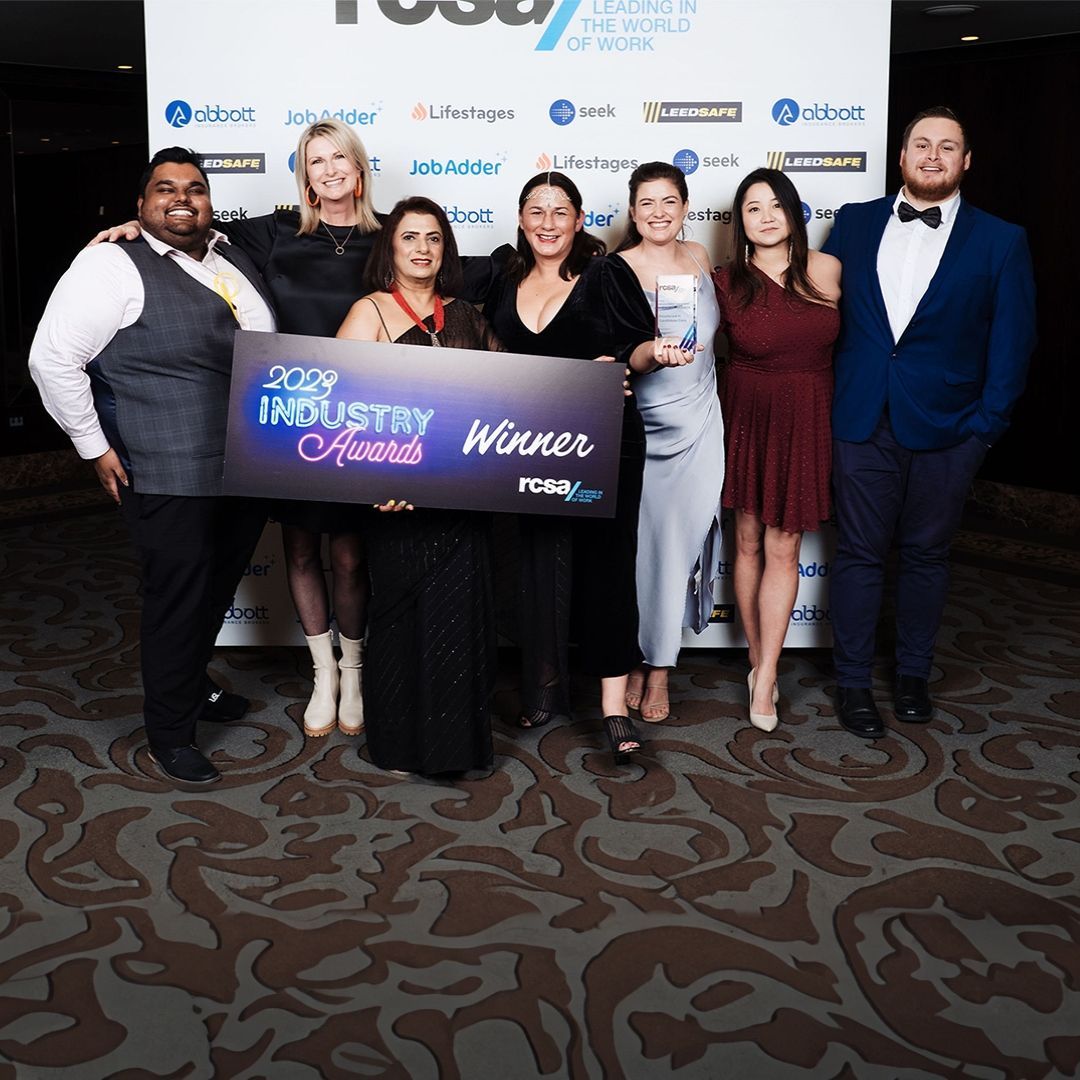 A group of people holding a sign that says industry winner