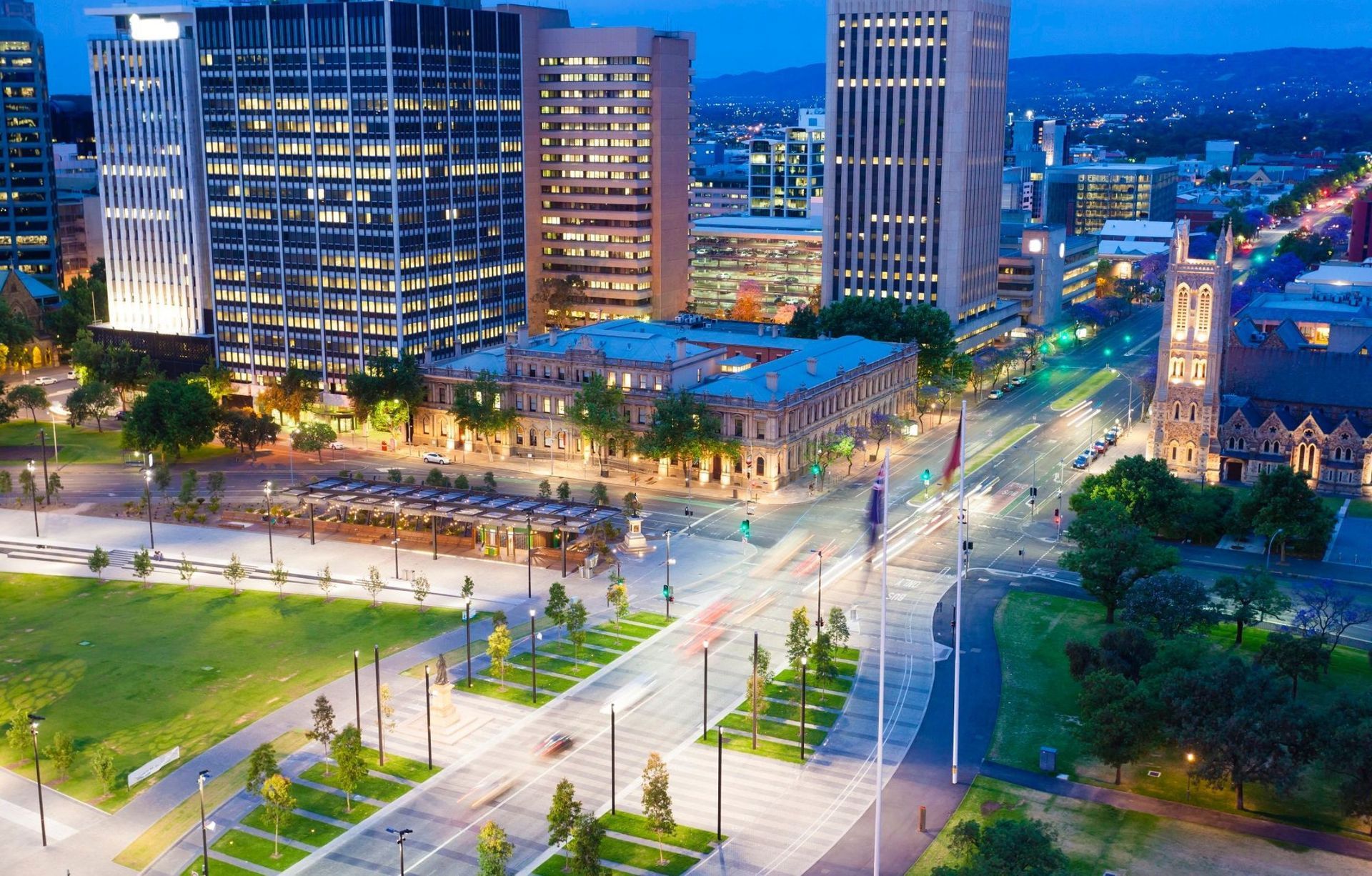 An aerial view of a city at night with a park in the foreground