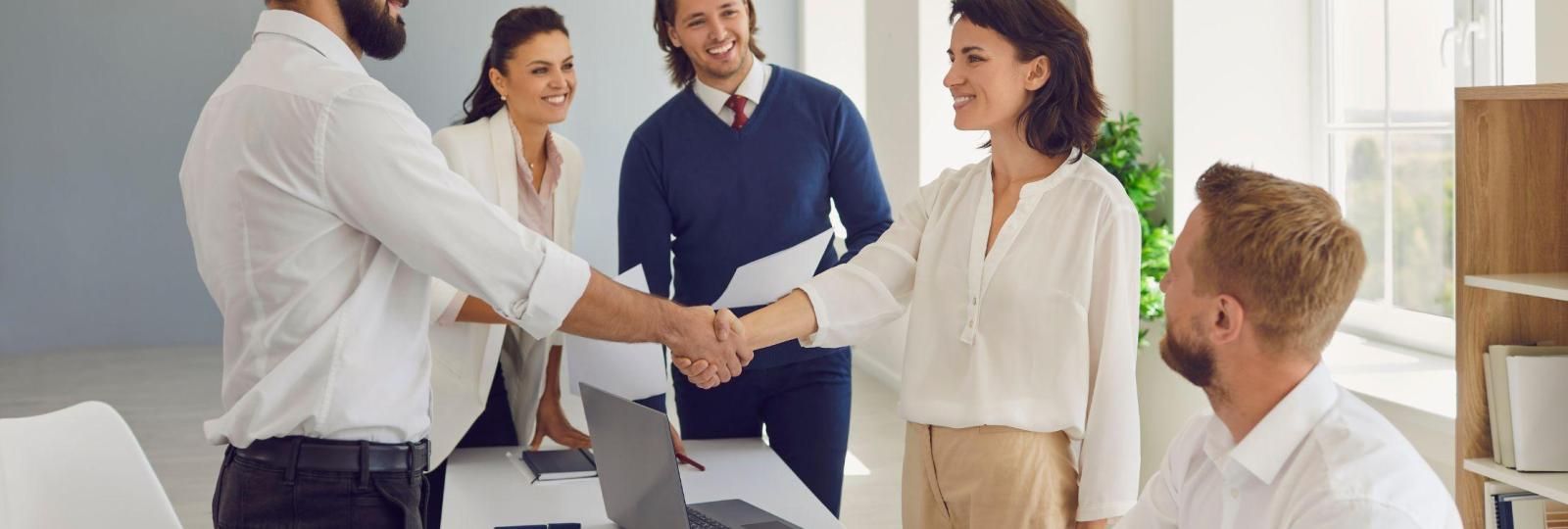 A group of people are shaking hands in an office.