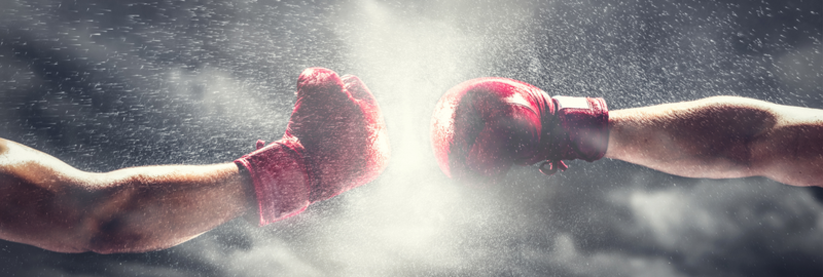 Two boxers are fighting each other in a boxing ring.