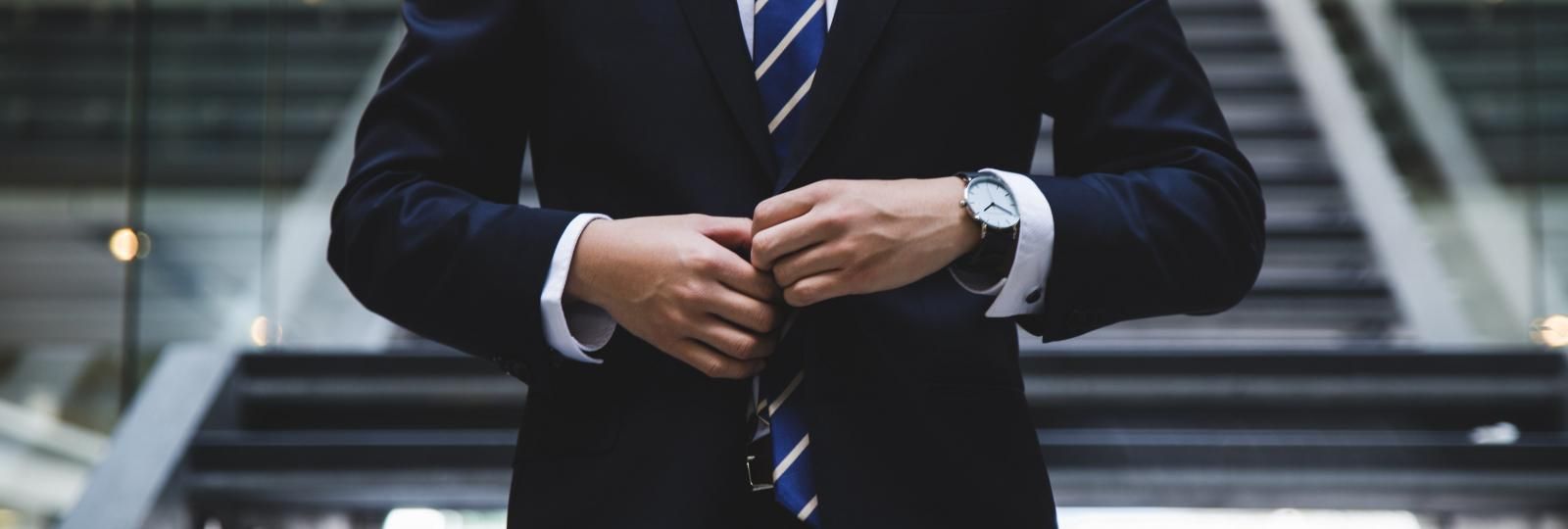 A man in a suit and tie is standing on a set of stairs.