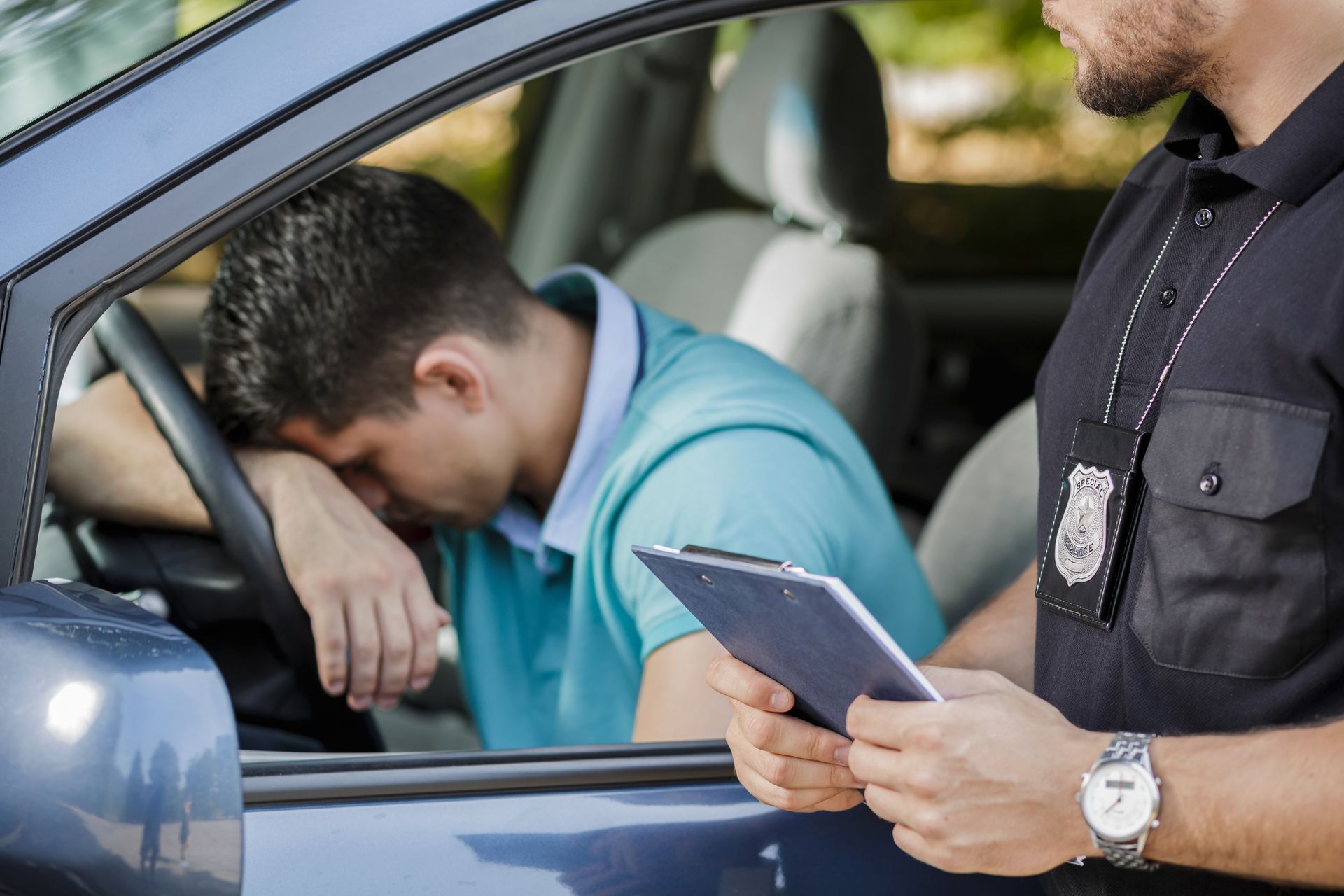 A police officer is talking to a man in a car.