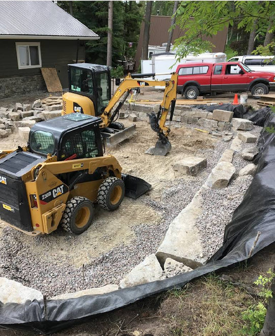 A bulldozer and an excavator are working on a construction site.