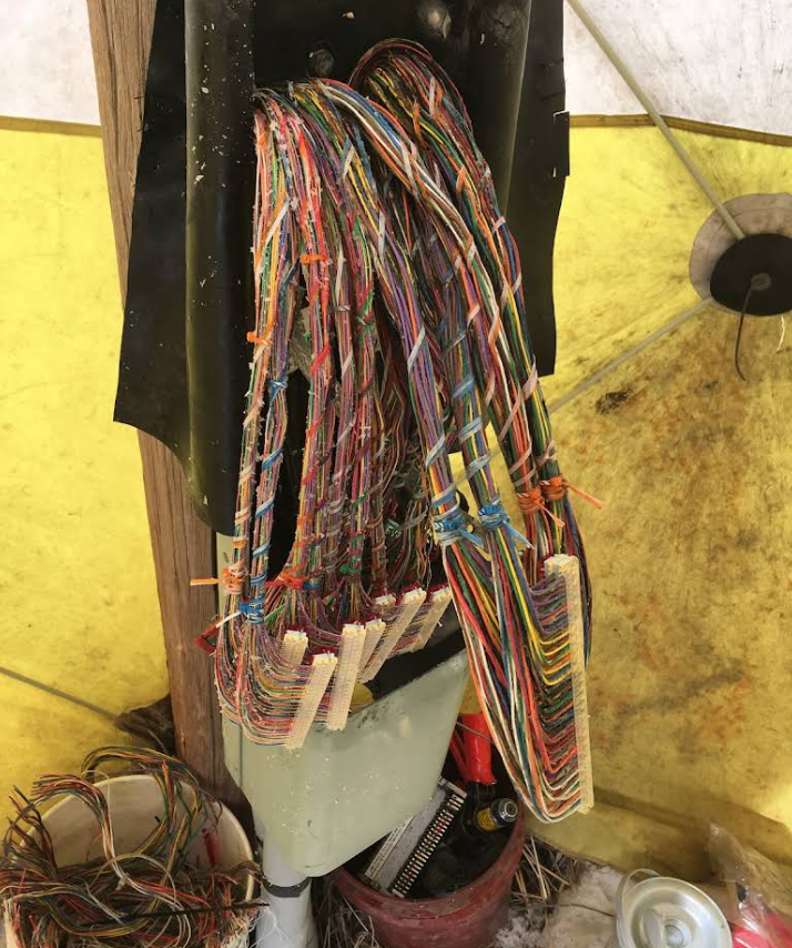 A bunch of wires are hanging from a pole