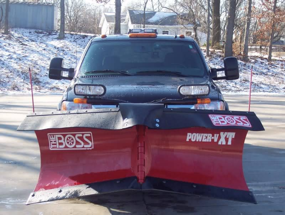 A boss snow plow is parked on the side of the road