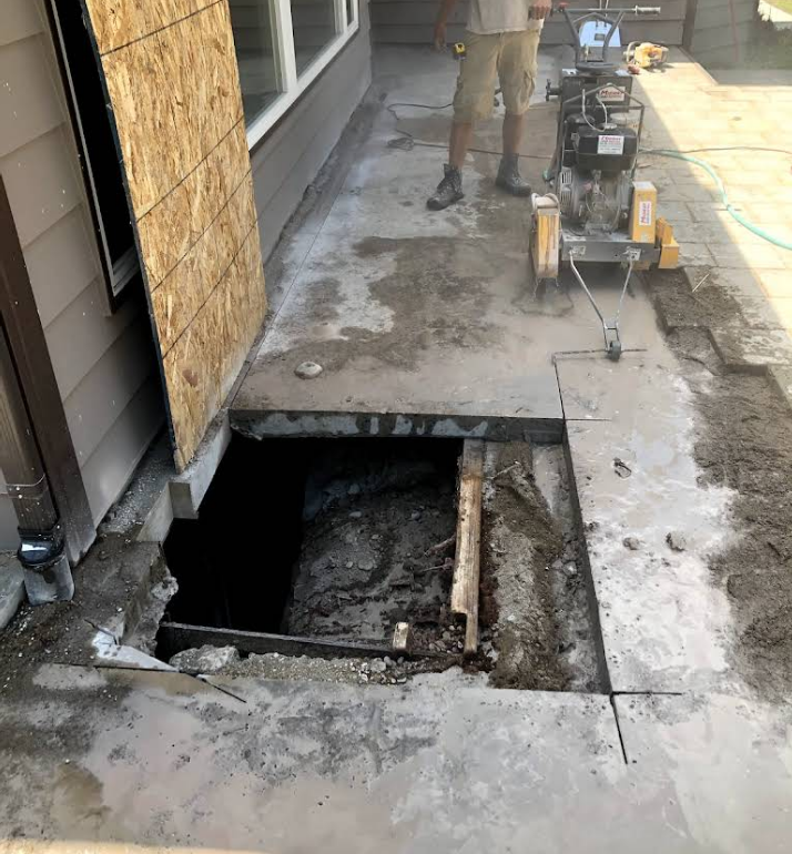 A man is using a machine to cut a hole in the ground