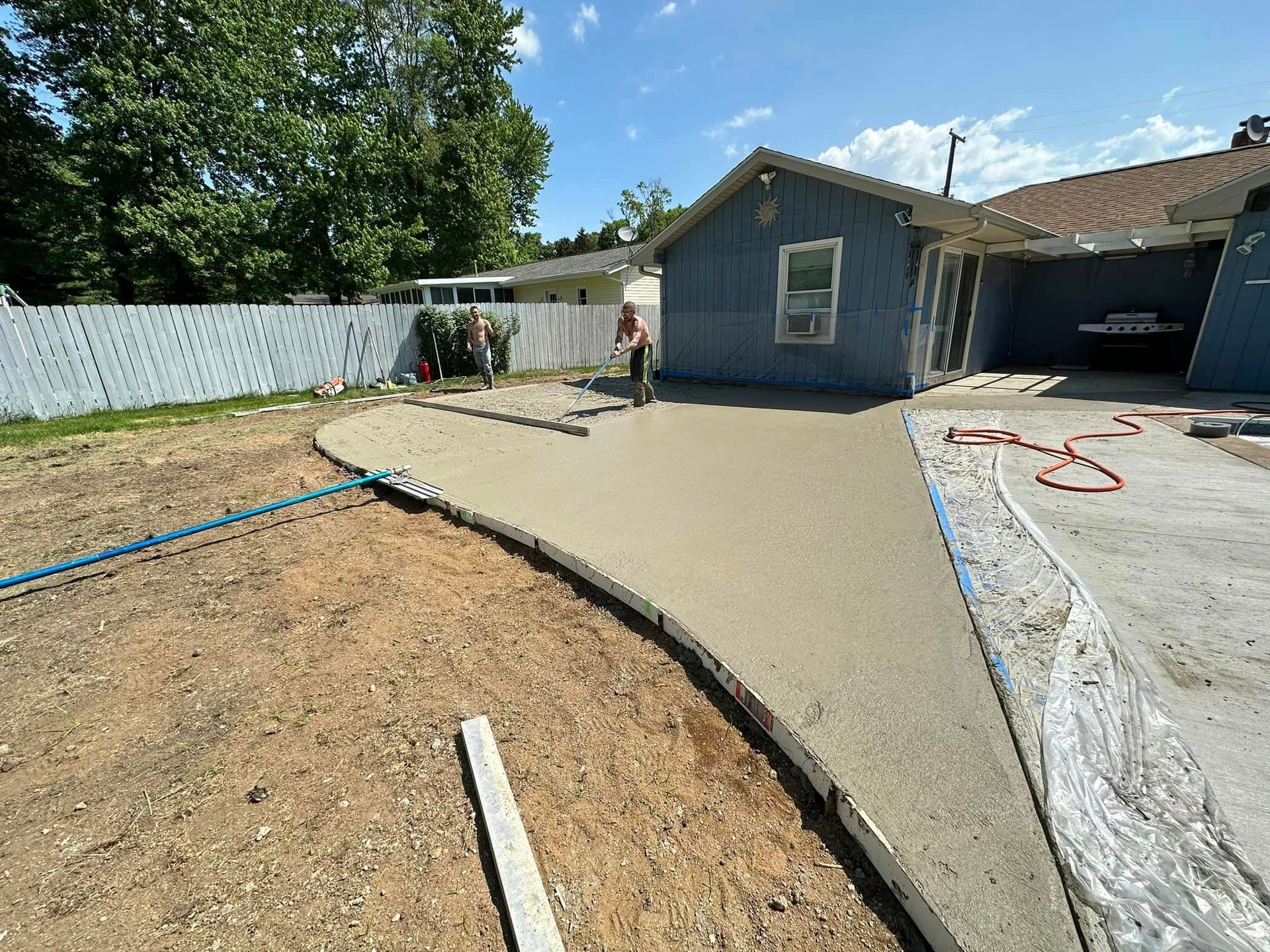 A concrete driveway is being built in front of a house.