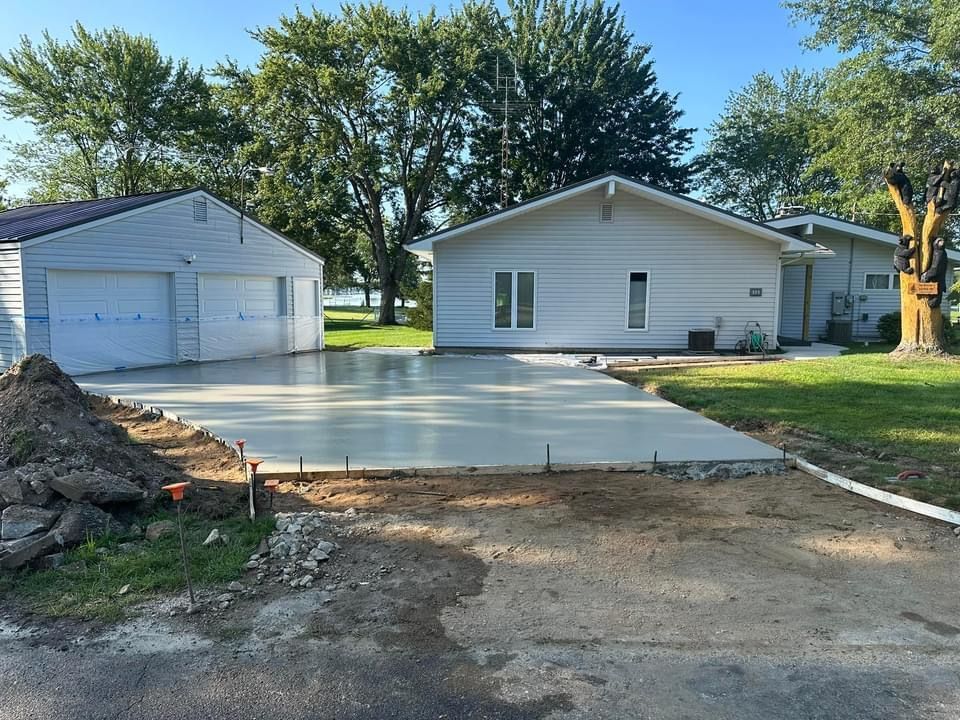 A concrete driveway is being built in front of a house.