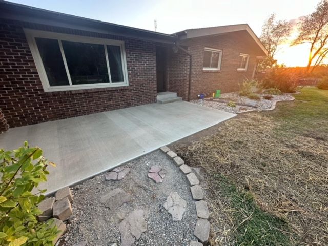 A brick house with a concrete walkway in front of it