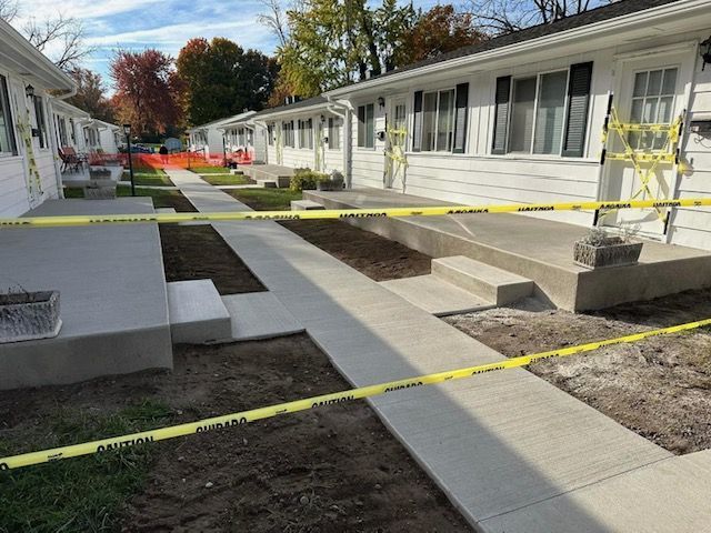A row of houses with a walkway surrounded by yellow tape