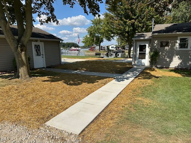A concrete walkway between two houses with trees in the background