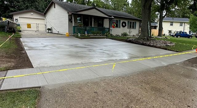 A concrete driveway is being built in front of a house.