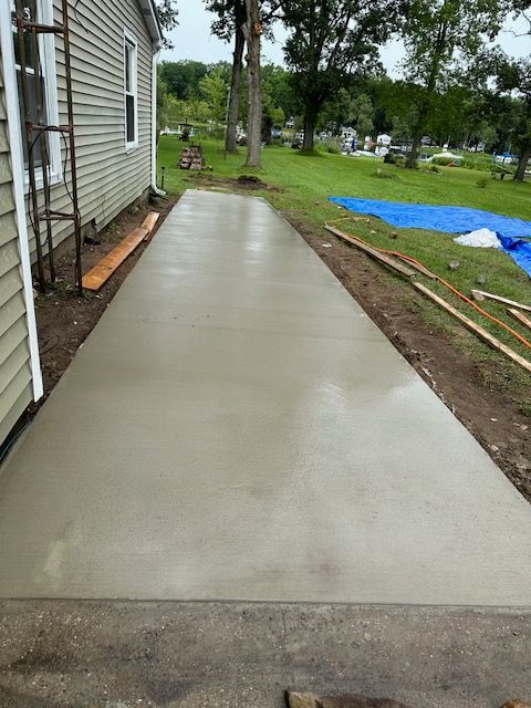A concrete driveway is being built in front of a house.