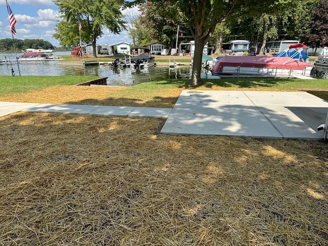 A boat is docked in the water next to a concrete walkway.