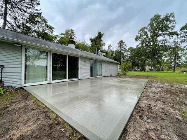 A concrete patio is being built in front of a house.