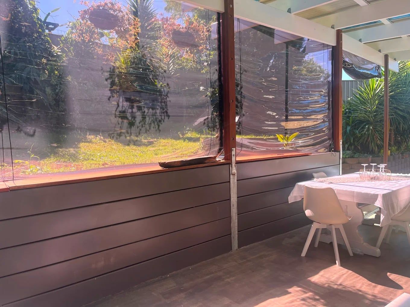 A table and chairs on a patio with a view of a garden — ZBM Constructions in Wollongbar, NSW
