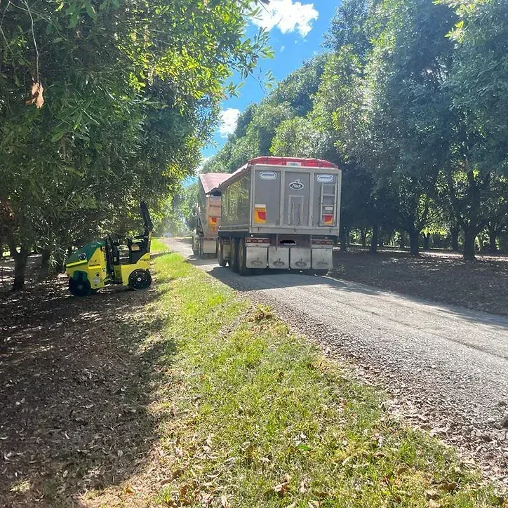 Two Dump Trucks Are Driving Down a Country Road — ZBM Constructions in Wollongbar, NSW