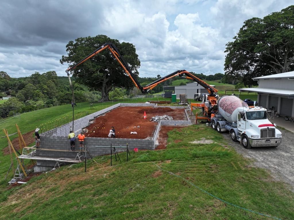 A truck is driving down a dirt road next to a construction site — ZBM Constructions in Wollongbar, NSW