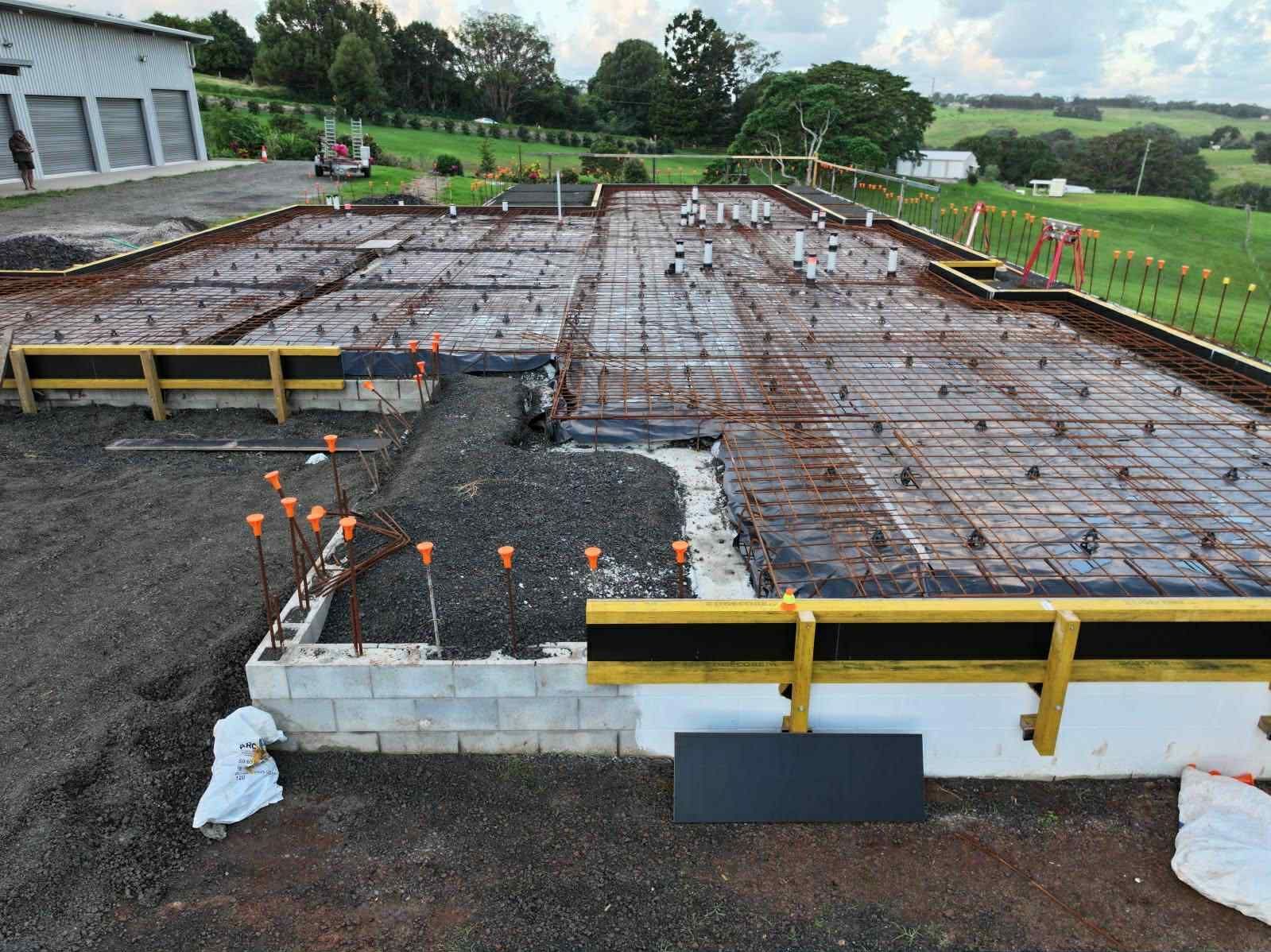 A concrete base for a house is being built in a field — ZBM Constructions in Wollongbar, NSW