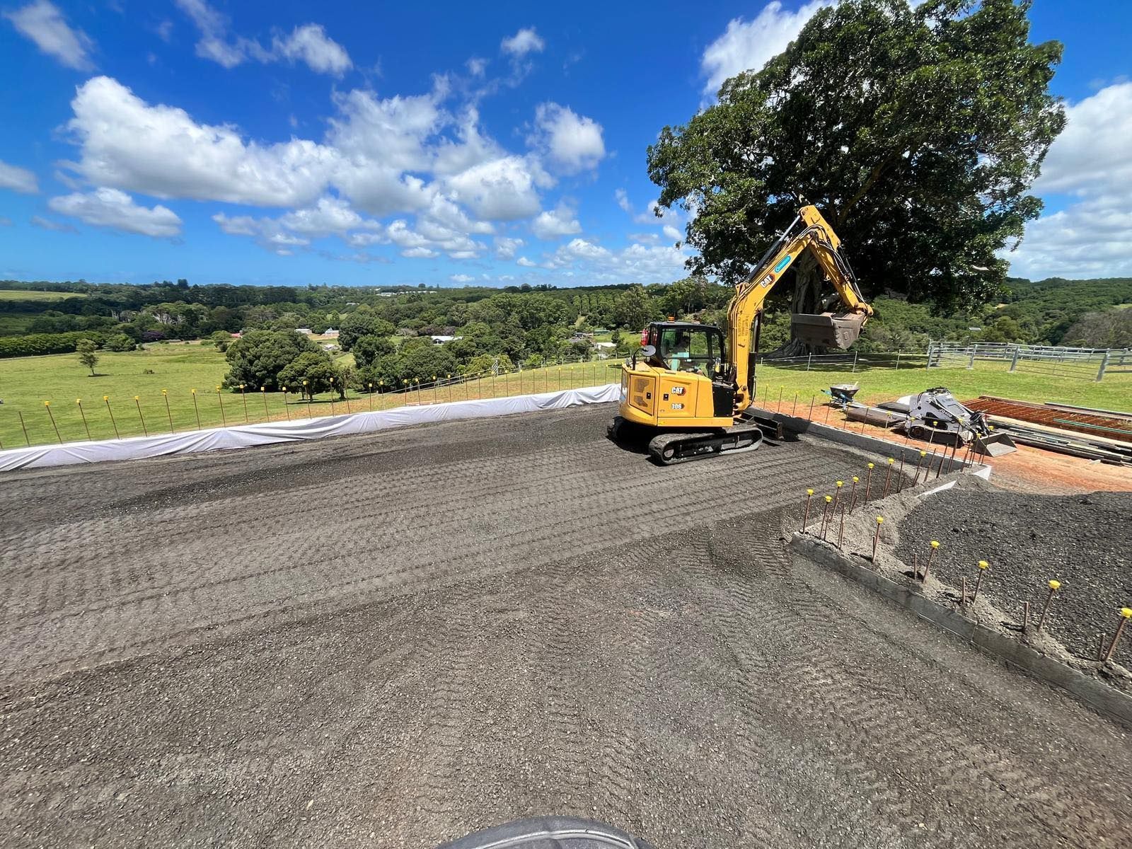 A yellow excavator is sitting on top of a dirt road — ZBM Constructions in Wollongbar, NSW