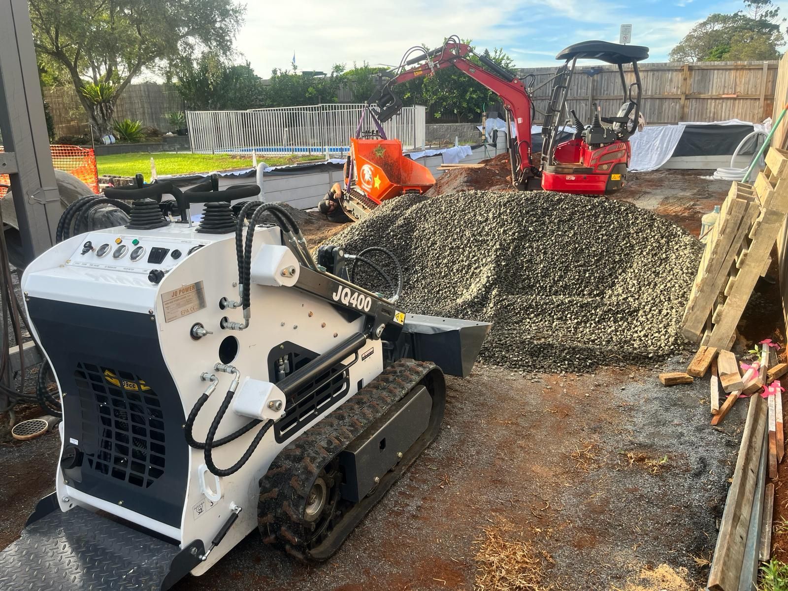 A Yellow Bulldozer Is Driving Down a Dirt Road — ZBM Constructions in Wollongbar, NSW