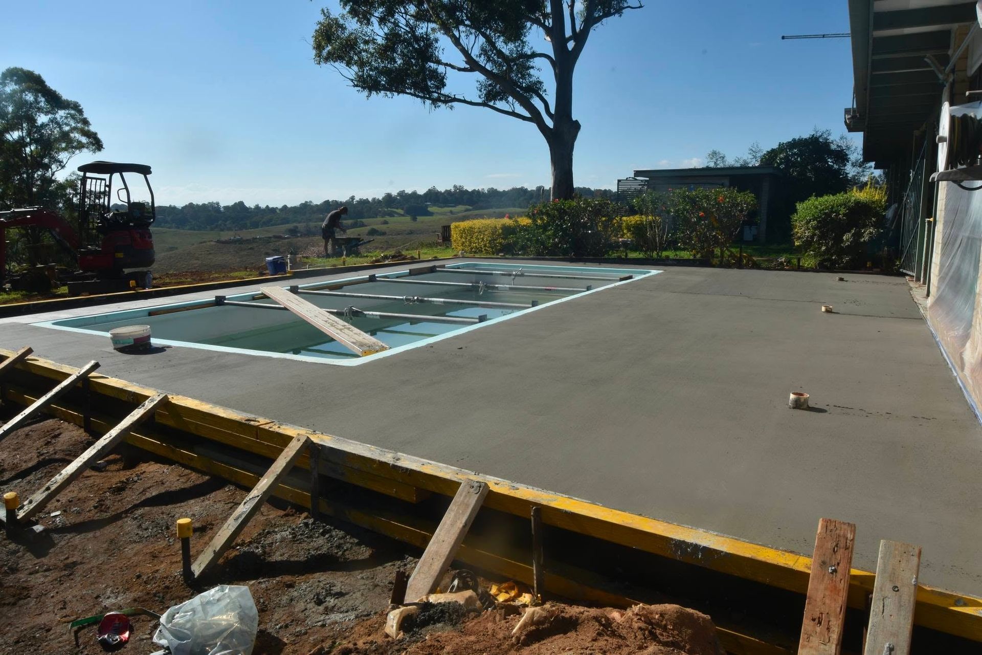 A concrete driveway is being built next to a swimming pool — ZBM Constructions in Wollongbar, NSW