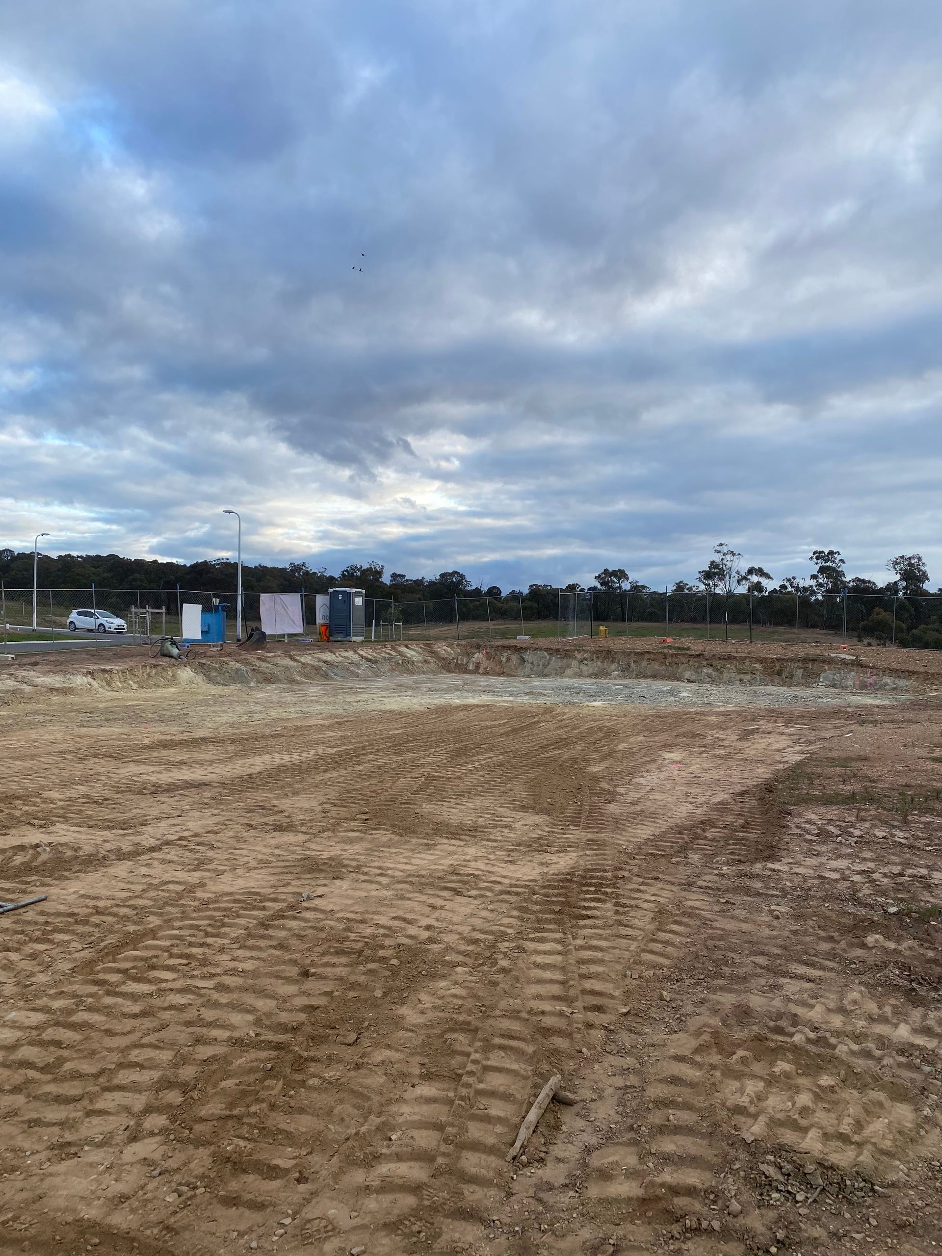 A bulldozer is sitting in the middle of a dirt field.