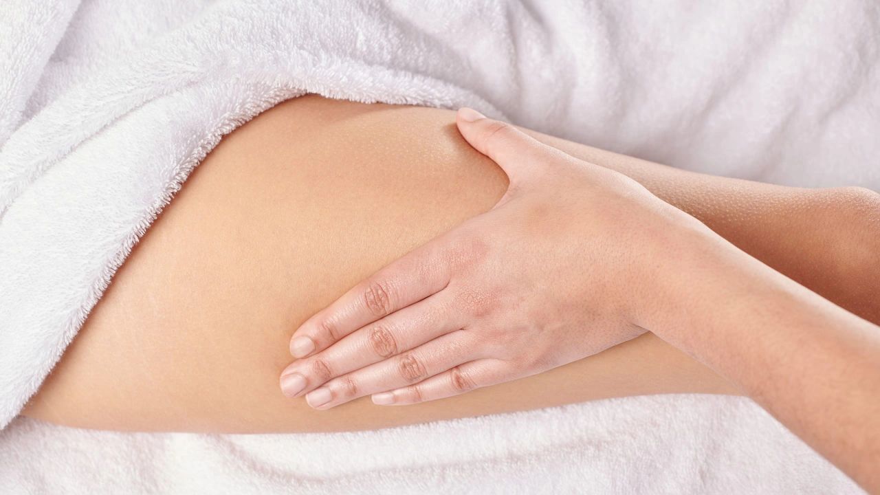 Hand massaging a leg, which is draped in white fabric.