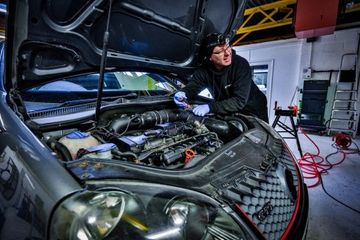 mechanic in a workshop repairing a car