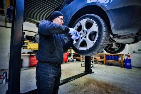 mechanic changing a wheel of a modern car in a workshop