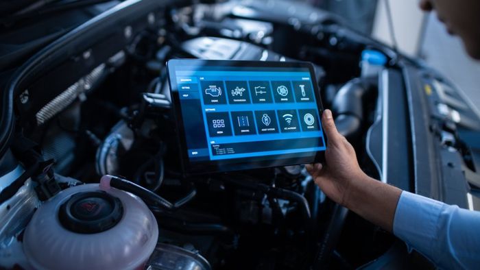mechanic uses a tablet computer with a futuristic interactive diagnostics software